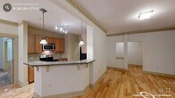 Located at 513 Cosgrove Ave in Chapel Hill, NC, this well-designed two-bedroom, two-bathroom residence offers a comfortable and functional single-floor layout. The open-concept living and kitchen area is anchored by warm hardwood flooring that flows throughout the main living spaces. The kitchen features warm-toned wood cabinetry, a tile backsplash, stainless steel appliances including an electric range and microwave, and a granite-topped peninsula with bar seating — ideal for casual dining or entertaining. Pendant lighting and a track light system add both style and practicality to the space. The living room is bright and open, with crown molding details, a decorative column, and large windows that invite natural light. Both bedrooms are carpeted and generously sized, with the primary bedroom offering ample space and direct access to a closet. The primary bathroom includes a dual-sink granite vanity, warm wood cabinetry, tile flooring, and a tub-shower combination. The second bathroom features a single granite vanity and tile flooring. A dedicated in-unit laundry room with a full-size washer and dryer adds everyday convenience. Two closets provide additional storage throughout the home.