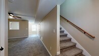 Located at 770 Needmore Road in Clarksville, Tennessee, this two-story home offers a practical and well-organized layout spread across two floors. The main level features a kitchen equipped with warm-toned wood cabinetry, black appliances including a range, microwave, dishwasher, and refrigerator, all set atop durable tile flooring. A door in the kitchen provides convenient access to the exterior. The lower level also includes a bedroom with tile flooring and a double-door closet, as well as a full bathroom featuring a tub/shower combo with white surround panels and tile flooring. A carpeted staircase with a wood handrail connects the two floors. Upstairs, the spacious primary bedroom features plush carpet, a ceiling fan, and an en-suite bathroom. Two additional bedrooms on the upper level offer carpet flooring, natural light through windows with blinds, and closet space. The second full bathroom mirrors the lower level's layout, with a clean tub/shower combo and tile floors. Neutral warm-beige tones carry throughout the home, creating a cohesive and inviting atmosphere well-suited for comfortable everyday living.
