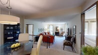 This single-floor residence offers a well-organized layout comprising two living areas, one bedroom, a dining room, a kitchen, and two full bathrooms. The main living area features plush carpeting, neutral walls, and large sliding glass doors that flood the space with natural light and provide views of lush outdoor greenery. A bold orange leather sofa set anchors the room, complemented by a glass-top coffee table and framed wall art. The second living area offers additional flexible space, also with sliding glass doors and garden views, ideal for use as a sitting room or home office. The dining room is defined by a stylish drum pendant light, a glass-top dining table, upholstered chairs, and warm wood louvered doors. The galley-style kitchen features dark cabinetry, light stone-look tile flooring, stainless steel appliances, and ample counter space. The primary bedroom is generously proportioned, with soft carpet, large windows overlooking outdoor scenery, and a calm, neutral palette. The bathrooms are well-finished, with one showcasing floor-to-ceiling stone-tiled walls and a frameless glass-enclosed walk-in shower. Throughout, the residence maintains a cohesive, classic aesthetic with warm tones and refined finishes.