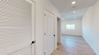 Located at 1564 Hi Point St in Los Angeles, this single-floor unit showcases a thoughtfully designed interior with a clean, modern aesthetic carried consistently throughout. Light oak hardwood flooring runs seamlessly across all rooms, complementing the crisp white walls and recessed lighting that keep the space bright and open.

The entryway welcomes residents through a rich dark wood arched door, flanked by louvered storage closets and setting a warm contrast against the otherwise contemporary palette. The kitchen is a standout feature, equipped with two-tone cabinetry — warm wood upper cabinets paired with lighter lower units — white quartz countertops, a bold blue patterned tile backsplash, stainless steel appliances including a gas range and dishwasher, and a sleek matte black faucet.

Bedrooms are generously proportioned with large windows drawing in abundant natural light and views of the surrounding Los Angeles neighborhood. One bedroom provides direct access to a private balcony with open city views. Closets feature built-in wire shelving systems for organized storage.

The bathrooms are finished with white subway tile surrounds, matte black framed sliding glass tub enclosures, and wood-toned vanity cabinetry, maintaining the modern yet warm design theme found throughout the home.