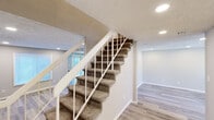 This two-story home in Macon, Georgia offers four bedrooms and three bathrooms across two well-proportioned floors. The main level features a combined kitchen and living area with light-toned luxury vinyl plank flooring, recessed lighting, and a textured ceiling. The kitchen is appointed with white shaker-style cabinetry, dark granite countertops, a teal glass tile backsplash, and black appliances including a refrigerator, range, and dishwasher. A hallway and bathroom round out the main floor.

Upstairs, carpeted stairs with white railings lead to the upper level, which houses the remaining bedrooms and bathrooms. The primary bedroom offers a comfortable footprint with recessed lighting. Additional bedrooms feature the same LVP flooring, neutral gray walls, recessed lighting, and windows that bring in natural light with views of the surrounding greenery. The bathrooms are finished with white vanities, tile flooring, and at least one tub surround clad in large-format marble-look tile. Throughout the home, clean lines, a consistent neutral palette, and modern finishes create a bright, move-in-ready atmosphere suited for everyday living.