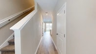 Located at 14153 Wind Row Dr in Jacksonville, FL, this two-story home offers a well-designed layout spread across two floors. The main level features an open-concept kitchen outfitted with white shaker cabinetry, granite countertops, recessed lighting, and stainless steel appliances, including a side-by-side refrigerator. The kitchen flows seamlessly into the living area, which is bathed in natural light and anchored by light wood-look flooring. A full-width sliding glass door opens directly to the backyard, creating a bright and airy connection to the outdoors. A half bathroom with wood-look flooring is also conveniently located on the main floor. The attached garage features a concrete floor and an automatic opener. Upstairs, the home provides two bedrooms, including a generously sized primary bedroom with plush carpeting and a walk-in closet equipped with wire shelving. A second closet offers additional storage. The upper floor is served by two full bathrooms and includes a dedicated laundry space with a full-size washer and dryer. A bright hallway connects the upper-level rooms, with light wood-look flooring continuing throughout. The home's neutral palette and clean finishes create a cohesive, move-in-ready environment.