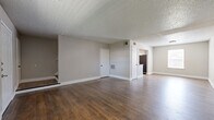 Located in Dallas, TX, this two-story, 2-bedroom, 2-bathroom home offers a well-organized layout spread across two floors. The main level features a generously sized living room with rich dark wood-look flooring, neutral gray walls, and a large window that allows natural light to fill the space. The kitchen is a standout, showcasing powder-blue shaker-style cabinetry with matte black hardware, granite countertops, a classic white subway tile backsplash, and stainless steel appliances including a range and refrigerator. A dedicated laundry area with a top-load washer and overhead shelving provides added convenience. The bathrooms are finished with gray vanity cabinetry, granite countertops, and framed mirrors, echoing the kitchen's cohesive aesthetic. Both bedrooms feature warm wood-look flooring, ceiling fans with integrated lighting, and windows that bring in natural light. The spacious primary bedroom offers generous room proportions and a closet. Textured ceilings and clean white baseboards throughout contribute to a consistent, move-in-ready finish. With a functional floor plan and tasteful updates, this home delivers comfortable everyday living in Dallas.