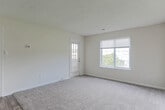 Located at 5800 Trellis Arch in Virginia Beach, Virginia, this single-floor residence offers a practical and well-organized layout designed for comfortable everyday living. The open-concept living area is generously sized, featuring neutral-toned carpet and light-colored walls that create a bright, welcoming atmosphere. A large window and exterior door allow natural light to fill the space while providing views of the surrounding neighborhood. The living area flows seamlessly into the kitchen, which is elevated by a peninsula-style counter that serves as both a workspace and a casual dining option. The kitchen is equipped with dark espresso cabinetry, black appliances including a full-size refrigerator and range, a stainless sink, and durable wood-look flooring that extends throughout the cooking and dining areas. The bedroom is a well-proportioned, carpeted room with a window that brings in natural light and outdoor views, offering a calm and restful environment. The bathroom features a full soaking tub with a grab bar, a toilet, a vanity, and the same warm wood-look flooring found in the kitchen, tying the space together cohesively. Clean white walls and neutral finishes throughout give the residence a move-in ready feel with ample opportunity for personalization.