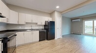 Located at 350 Bobolink Ridge in Ottawa's west end, this well-appointed one-bedroom, one-bathroom unit offers a practical and modern layout across a single floor. Light wood-look flooring runs continuously throughout the space, creating a cohesive and clean aesthetic.

The kitchen is designed for efficiency, featuring crisp white cabinetry extending to the ceiling for generous storage, dark granite-style countertops, and a full suite of black appliances including a range, dishwasher, and refrigerator. An under-cabinet range hood and a double-basin sink with a modern faucet complete the functional workspace.

The open living area is bright and airy, benefiting from a sliding glass door that leads to a private balcony with outdoor views. A wall-mounted ductless mini-split system provides both heating and cooling comfort, complemented by baseboard heaters along the perimeter walls.

The bedroom is a well-sized, quiet retreat featuring a large double-door closet and a window that brings in natural light with views of the surrounding neighbourhood.

The bathroom is finished with warm wood-toned cabinetry, a dark stone countertop with an undermount sink, and a full soaker tub and shower combination with recessed lighting overhead.