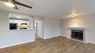 Located in Mountlake Terrace, WA, this 2-bedroom, 2-bathroom home offers a well-organized, single-floor layout designed for comfortable everyday living. The open-concept living, dining, and kitchen area serves as the heart of the home, featuring wood-look luxury vinyl plank flooring, a ceiling fan, a cozy fireplace with a classic mantel, and a sliding glass door that opens to a private balcony with outdoor views. Natural light flows in through multiple windows, enhancing the bright, neutral color palette throughout.

The kitchen is appointed with white cabinetry, white countertops, a stainless steel sink, and black appliances including an electric range and refrigerator. A hallway connects the main living space to the private quarters, where an in-unit stacked washer and dryer add everyday convenience.

Both bedrooms are carpeted and generously proportioned, each offering closet storage. The primary bedroom includes a well-sized closet and comfortable layout. The two bathrooms feature wood-look tile flooring, white vanities, and clean, functional finishes. Three closets throughout the home provide ample storage. The space presents a clean, move-in-ready aesthetic with practical amenities throughout.