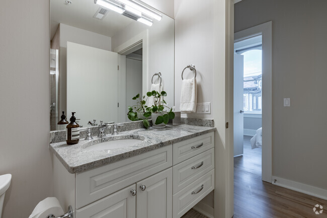 Baño con azulejos y bañera profunda y una encimera de granito. - The Block