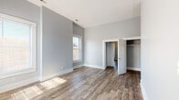 Located at 1715 Magazine Street in Louisville, Kentucky, this 3-bedroom, 1.2-bathroom home offers a well-appointed single-floor layout with consistent, modern finishes throughout. Wide-plank wood-look flooring runs seamlessly across the living spaces, complemented by cool gray walls and crisp white trim that create a clean, contemporary aesthetic.

The bedrooms are generously sized, with several featuring notably high ceilings that enhance the sense of openness. Natural light flows in through multiple windows dressed with vertical blinds, and at least one bedroom includes a built-in closet. Ceiling fans add comfort to the smaller bedroom areas.

The kitchen is outfitted with dark gray shaker-style cabinetry, granite countertops with subtle veining, and a stainless steel double-basin sink — a practical and stylish combination. The bathrooms maintain the home's neutral palette with light gray walls and gold-toned hardware accents.

A staircase with white balusters is visible in the layout, suggesting additional access points within the structure. The open and airy hallway connects the rooms efficiently, making the floor plan feel both functional and spacious. Overall, this home presents a refreshed, move-in-ready interior well-suited for comfortable everyday living in the heart of Louisville.