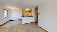 Located at 1320 Coach Rd in Saint Paul, Minnesota, this single-floor unit offers a functional and comfortable layout across several well-defined living areas. The galley-style kitchen is outfitted with light wood cabinetry, dark laminate countertops, white appliances including a refrigerator, electric range, and dishwasher, and durable wood-look flooring. A pass-through counter connects the kitchen to the adjacent dining and living areas, creating an open, communicative flow. The living room is a standout feature of the unit, highlighted by a tile-surround fireplace with a white wood mantel and plush wall-to-wall carpeting, offering a warm and inviting atmosphere. A pendant light fixture adds a subtle decorative touch to the dining area. The bedrooms are carpeted and quiet, each featuring closets with sliding doors and windows that allow natural light to filter in. One bedroom includes vertical blinds framing an outdoor-facing window. The bathroom is clean and straightforward, featuring a full tub and shower combination, a vanity with mirror, and wood-look flooring. Textured ceilings and neutral wall tones throughout give the unit a consistent, understated aesthetic well suited for comfortable everyday living.