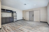 Located at 517 Grand Canyon Dr in Madison, WI, this 2-bedroom, 1-bathroom unit offers a practical and modern layout across a single floor. Light wood-style vinyl flooring runs throughout, lending a clean and cohesive look to the entire space.

The main living area is open and well-proportioned, anchored by a kitchenette that includes dark cabinetry, a stainless steel refrigerator, microwave, and a sink with additional counter space. A mirrored wet bar area with wood cabinetry adds a functional and stylish touch to the common space, visible from both the entry and the corridor.

The generously sized primary bedroom is a standout feature, offering ample room for comfortable furnishing. It includes a wall-mounted flat-screen TV, an open closet with a hanging rod, a vanity sink, and large windows dressed with neutral curtains that invite natural light. A second bedroom provides a quieter, more intimate space, also finished with the same flooring and neutral wall tones, with window treatments for privacy.

The bathroom is bright and clean, featuring a full soaking tub with a marble-style surround and a chrome grab bar, combining accessibility with a polished aesthetic. Throughout the unit, recessed lighting and neutral wall finishes create a calm, functional ambiance well-suited for everyday living.