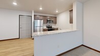 Located at 25749 4th Street West in Zimmerman, MN, this single-floor 2-bedroom, 1-bathroom residence offers a thoughtfully designed layout that maximizes functionality and comfort. The open-concept living, dining, and kitchen area serves as the heart of the home, where light-toned luxury vinyl plank flooring flows seamlessly through the kitchen and transitions to plush carpeting in the living space. A ceiling fan enhances the living area's comfort and airflow.

The kitchen is equipped with stainless steel appliances, including a refrigerator, range, built-in microwave, and dishwasher. Rich dark-toned cabinetry pairs with light granite-style countertops, and a peninsula with an overhang provides additional workspace and casual dining potential. Recessed lighting illuminates the kitchen efficiently.

Both bedrooms feature wall-to-wall carpeting, natural light from windows, and access to closet storage — with three closets distributed throughout the unit. The primary bedroom is a generous, private retreat with its own dedicated closet.

The full bathroom is finished with light wood-look flooring, a tub/shower combination, a dark-wood vanity with a light countertop, and clean white walls. A utility room rounds out the functional spaces within this well-appointed residence.
