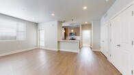 This well-designed single-floor residence offers a clean, contemporary aesthetic with a cohesive palette of soft neutral tones and quality finishes throughout. The open-concept living and dining area is anchored by warm light wood-style flooring, recessed lighting, and a generous layout that allows for flexible furnishing arrangements. Natural light filters in through slatted blinds, enhancing the bright and airy atmosphere.

The kitchen is a standout feature, showcasing modern wood-grain cabinetry, light stone countertops, a classic white subway tile backsplash, and a full suite of stainless steel appliances including a range, microwave, and refrigerator. A peninsula counter provides additional prep space and a natural division between the kitchen and living area. Pendant lighting adds a refined touch overhead.

The bedrooms offer plush carpeting, ceiling fans, and ample natural light from large windows with blinds. The primary bedroom includes a spacious walk-in closet. Additional rooms feature generous double-door closets and light hardwood-style flooring, offering versatile use as a bedroom or flex space.

The bathroom is finished with large-format tile flooring, a wood-grain vanity with an undermount sink, a lighted mirror, and a full tub-shower combination. Recessed and vanity lighting ensure a well-lit, functional space. Overall, the residence presents a polished, move-in-ready environment with thoughtful design details throughout.