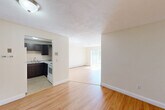 Located at 590 Middle St, Unit 304, in Weymouth, MA, this well-laid-out 2-bedroom, 2-bathroom residence offers a comfortable and functional living experience across a single floor. The open layout connects the kitchen and living areas seamlessly, with warm hardwood flooring running throughout. The living room is a bright, inviting space anchored by a large sliding glass door that fills the room with natural light and provides access to the outdoors. A wall-mounted air conditioning unit and baseboard heating ensure year-round comfort. The kitchen features dark cabinetry, granite-style countertops, a sink, and white appliances, with tile flooring that complements the rest of the home. A distinctive design element throughout the unit is the exposed brick accent walls, which add warmth and character to the entrance and bathrooms. Both bathrooms carry this brick detailing, with one featuring a tub-shower combination. The two bedrooms are generously proportioned, with the primary bedroom offering ample natural light through a dedicated window and baseboard heating. Both bedrooms include closets, contributing to the four total closets found throughout the unit. A hallway connects the private and common areas, completing this well-organized and charming residence.