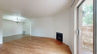 This single-floor, 3-bedroom, 3-bathroom unit offers a thoughtfully arranged layout designed for comfortable everyday living. The living room serves as the heart of the home, featuring warm hardwood-style flooring, vaulted ceilings that add a sense of openness, a classic wood-burning fireplace set against a tiled hearth, and a sliding glass door that invites natural light and provides access to an outdoor area. The dining room is conveniently positioned adjacent to the living space and is distinguished by large-format tile flooring and an elegant chandelier overhead. The galley-style kitchen is efficiently designed with white cabinetry, tile flooring, black appliances including an electric range and refrigerator, and ample counter space. Each of the three bedrooms features hardwood-style flooring and bright white walls, with the primary bedroom offering generous proportions. The bedrooms are served by well-appointed bathrooms, one of which includes a tub-shower combination with classic subway tile surround, a vanity with white cabinetry, and tile flooring. A dedicated closet and hallway complete the floor plan, rounding out this functional and comfortable single-level residence.