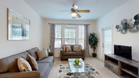 Located in Clermont, FL, this single-floor 2-bedroom, 2-bathroom residence offers a thoughtfully designed layout across a comfortable living footprint. The bright living room features plush carpeting, a ceiling fan, and large windows that fill the space with natural light, creating a warm and welcoming ambiance. Adjacent to the living area, the open dining space flows seamlessly into a galley-style kitchen outfitted with warm wood cabinetry, light countertops, tile flooring, and a full suite of appliances including a range, refrigerator, dishwasher, and built-in microwave. A convenient breakfast bar connects the kitchen to the main living and dining area. The spacious primary bedroom offers generous proportions, carpeted flooring, natural light from multiple windows, and access to a large walk-in closet with wire shelving. Both bathrooms are well-appointed, with one featuring a tiled tub-shower combination and wood-tone vanity cabinetry. A dedicated in-unit laundry area with a full-size washer and dryer adds everyday convenience. The home also includes an entrance foyer, four closets for ample storage, and a private patio. The overall design is clean, neutral, and move-in ready.