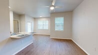 Located in Dallas, TX, this single-story 2-bedroom, 2-bathroom unit offers a functional and comfortable layout. The kitchen is a standout feature, boasting warm wood cabinetry, white appliances including a range and refrigerator, a double sink, and generous counter space with a breakfast bar — all illuminated by recessed and overhead lighting. Wood-look flooring runs throughout the entire unit, lending a cohesive and easy-to-maintain aesthetic. The primary bedroom is a well-proportioned retreat with a large window dressed in white horizontal blinds, allowing for ample natural light and views of surrounding greenery. It connects to a dedicated closet outfitted with multi-tiered wire shelving systems for organized storage. The second bedroom also features wood-look floors and a natural light-filled window. Both bathrooms are designed with accessibility in mind, featuring stainless steel grab bars, a shower-tub combo with a curtain rod, wood cabinetry vanities, and wood-look flooring. Two hallways connect the rooms, contributing to a smooth and practical flow throughout the unit. Neutral gray walls and clean white trim complete the bright, understated interior palette.