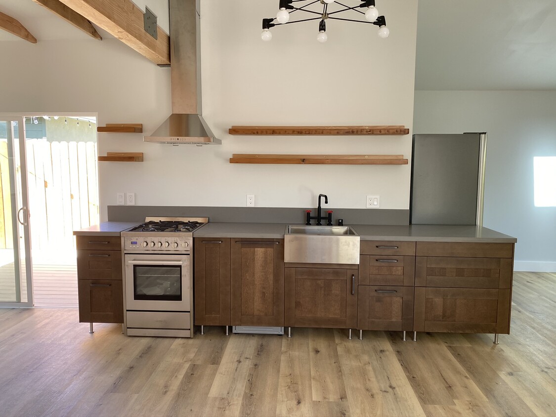 Modern kitchen with gas range, dishwasher, farm sink, quartz countertops. Opens to a private patio.. - 3605 Helms Ave