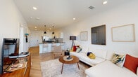 This single-floor residence showcases a thoughtfully designed open-concept layout that seamlessly connects the living, dining, and kitchen areas. The living room is bright and welcoming, featuring large windows that allow abundant natural light and offer views of the surrounding neighborhood. Herringbone-patterned light wood flooring flows throughout the main living spaces, adding a refined architectural touch.

The kitchen is a standout feature, outfitted with a two-tone cabinetry scheme — crisp white upper cabinets paired with charcoal lower cabinets — complemented by a classic white subway tile backsplash and dark countertops. A full suite of stainless steel appliances, including a French door refrigerator, electric range, microwave, and dishwasher, make this kitchen as functional as it is attractive. Pendant lighting over the kitchen island adds a modern finishing touch.

The bedroom is a serene retreat, carpeted for comfort, and equipped with a ceiling fan and a large window that provides natural light and outdoor views. The full bathroom features herringbone tile flooring, a white vanity with black hardware, and a soaking tub with shower, maintaining the cohesive modern aesthetic found throughout the space. Recessed lighting and clean white walls complete the bright, contemporary ambiance of this well-appointed residence.