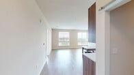 Located at 2803 Poag St in Alexandria, VA, this well-appointed 3-bedroom, 3-bathroom unit offers a thoughtfully designed single-floor layout with a clean, modern aesthetic throughout. The open-concept kitchen and living area serves as the heart of the home, featuring wood-toned cabinetry extending floor to ceiling, stainless steel appliances, a white subway tile backsplash, light countertops, and track lighting overhead. Light hardwood-style flooring flows through the main living and kitchen areas, adding warmth and continuity to the space. The living area is filled with natural light from multiple large windows dressed with horizontal blinds, offering pleasant views of the surrounding Alexandria neighborhood. Each of the three bedrooms is generously sized with plush carpeting and large windows that frame bright, elevated views of the community and greenery beyond. The primary bedroom includes a dedicated closet, providing practical storage. All three bathrooms are finished with neutral tile flooring, clean white subway tile surrounds in the tub and shower areas, and warm wood-toned vanity cabinetry. The overall design palette of warm neutrals, natural textures, and contemporary fixtures creates a cohesive, inviting atmosphere throughout the entire unit.