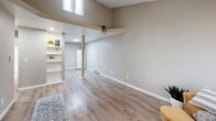 Located in Bremerton, WA, this 2-bedroom, 1-bathroom single-level home offers a thoughtfully designed layout with modern updates throughout. Light-toned luxury vinyl plank flooring runs consistently across the living areas, complementing the neutral warm-gray walls and crisp white trim that give the space a clean, contemporary feel.

The open living area is a standout feature, boasting soaring vaulted ceilings that lend a sense of openness well beyond its physical footprint. High clerestory windows draw in natural light from above, while built-in open shelving adds both character and practicality to the space. A structural column adds an architectural detail that subtly defines the transition between the living and kitchen areas. The kitchen is equipped with white cabinetry, a white range, and a refrigerator.

Both bedrooms feature large windows that frame outdoor greenery, providing ample natural light and a connection to the surroundings. Each room includes its own closet and baseboard heating. The primary bedroom is a comfortable, private retreat. The bathroom is outfitted with a full tub-shower combination with a clean white surround.

A connecting hallway and four closets throughout the home ensure generous storage. The textured ceilings add a classic touch, rounding out this efficiently designed and updated home.