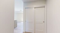 Located at 7219 Sharon Ave in Niagara Falls, Ontario, this thoughtfully designed one-bedroom, two-bathroom unit offers a clean, contemporary aesthetic throughout its efficiently laid-out single floor. Light hardwood flooring runs consistently through the main living areas, creating a warm and cohesive feel.

The kitchen is a standout feature, showcasing a large island with a light wood base and white quartz countertop, complemented by matching upper cabinetry and a subway tile backsplash. Stainless steel appliances, including a refrigerator, stove, and built-in microwave, add a polished, functional touch. The open-concept layout allows the kitchen to flow naturally into the living area, making the space feel open and connected.

The bedroom is bright and inviting, featuring a large window overlooking lush greenery, a double-door closet offering generous storage, and the same warm hardwood flooring found throughout the unit. The neutral wall tones contribute to a calm and restful atmosphere.

Both bathrooms are finished with modern fixtures. One bathroom features a stylish vanity with light wood cabinetry, a white quartz countertop, and large-format tile flooring, reflecting the same design language carried throughout the unit. A hallway connects all areas of the floor plan seamlessly. Overall, this unit presents a fresh, modern living environment with consistent, quality finishes.