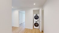 Located on the 9th floor at 351 Marin Blvd in Jersey City, this modern 2-bedroom, 2-bathroom residence offers a well-designed layout with a clean, contemporary aesthetic throughout. Light-toned hardwood flooring flows seamlessly across the entire unit, complementing the crisp white walls and black-framed floor-to-ceiling windows that frame sweeping views of the Jersey City skyline and surrounding neighborhood.

The open-concept kitchen and living area serves as the heart of the home, anchored by a large central island with a dark quartz countertop, integrated sink, and pendant lighting above. The kitchen is outfitted with gray cabinetry, a white subway tile backsplash, stainless steel appliances, and recessed lighting, creating a polished and functional space.

Both bedrooms are generously proportioned, with the spacious primary bedroom offering ample room for furnishings. Each bedroom benefits from large windows that allow abundant natural light and provide elevated city views. Closet space is well integrated throughout.

The two bathrooms are finished in a modern style — one featuring a walk-in glass shower with large-format gray tile surround, and the other with a light wood vanity, white countertop, and a mirrored medicine cabinet above. Each bathroom is clean and efficiently designed, completing this thoughtfully planned urban residence.