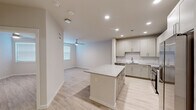 Located at 1610 Campbell Road in Houston, TX, this well-appointed one-bedroom, one-bathroom unit offers a thoughtfully designed open-concept layout across a single floor. Light wood-tone flooring runs throughout, complementing the neutral color palette that gives the space a clean, contemporary feel.

The kitchen is a standout feature, boasting gray shaker-style cabinetry, granite countertops, a classic white subway tile backsplash, and a full suite of stainless steel appliances including a French door refrigerator, range with microwave hood, and dishwasher. A central island with matching granite provides additional prep space and casual seating. Recessed lighting illuminates the kitchen and flows into the open living area, which features a ceiling fan and a window dressed with blinds for natural light.

The bedroom is a comfortable, well-proportioned room with light-filled windows, a ceiling fan, and light wood flooring. The full bathroom is finished with granite countertops, gray cabinetry, a large mirror, and a glass-enclosed tiled shower. Directly accessible from the bathroom is a dedicated walk-in closet equipped with wire shelving systems, offering practical and organized storage. The unit's cohesive modern design and quality finishes make it a functional and attractive living space.