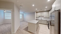 Located at 1610 Campbell Road in Houston, TX, this well-appointed one-bedroom, one-bathroom unit offers a thoughtfully designed open-concept layout across a single floor. Light wood-tone flooring runs throughout, complementing the neutral color palette that gives the space a clean, contemporary feel.

The kitchen is a standout feature, boasting gray shaker-style cabinetry, granite countertops, a classic white subway tile backsplash, and a full suite of stainless steel appliances including a French door refrigerator, range with microwave hood, and dishwasher. A central island with matching granite provides additional prep space and casual seating. Recessed lighting illuminates the kitchen and flows into the open living area, which features a ceiling fan and a window dressed with blinds for natural light.

The bedroom is a comfortable, well-proportioned room with light-filled windows, a ceiling fan, and light wood flooring. The full bathroom is finished with granite countertops, gray cabinetry, a large mirror, and a glass-enclosed tiled shower. Directly accessible from the bathroom is a dedicated walk-in closet equipped with wire shelving systems, offering practical and organized storage. The unit's cohesive modern design and quality finishes make it a functional and attractive living space.