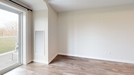 Located at 57 Riverview Dr in Chatham-Kent, Ontario, this well-designed two-bedroom, one-bathroom unit offers a thoughtfully laid-out single-floor plan with a clean, contemporary aesthetic throughout. The open-concept kitchen and living area forms the heart of the home, showcasing rich dark wood cabinetry, a large peninsula with a light quartz countertop and double undermount sink, and a full suite of stainless steel appliances including a range, over-the-range microwave, dishwasher, and refrigerator. Subway tile backsplash and recessed lighting complete the polished kitchen finish. Light-toned hardwood-style flooring flows seamlessly through the main living areas, creating a warm and cohesive feel. The entry features built-in cabinetry for added storage alongside a closet. Both bedrooms are comfortably sized with neutral tones, hardwood-style flooring, and windows that overlook a serene green landscape with open skies — ideal for natural light and peaceful views. The primary bedroom offers generous proportions and direct access to the bathroom. The bathroom is finished with white cabinetry, a quartz vanity, and a glass-enclosed tiled shower. An outdoor view of the surrounding greenery adds a tranquil backdrop to this modern, move-in-ready unit.
