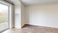 Located at 57 Riverview Dr in Chatham-Kent, Ontario, this well-designed two-bedroom, one-bathroom unit offers a thoughtfully laid-out single-floor plan with a clean, contemporary aesthetic throughout. The open-concept kitchen and living area forms the heart of the home, showcasing rich dark wood cabinetry, a large peninsula with a light quartz countertop and double undermount sink, and a full suite of stainless steel appliances including a range, over-the-range microwave, dishwasher, and refrigerator. Subway tile backsplash and recessed lighting complete the polished kitchen finish. Light-toned hardwood-style flooring flows seamlessly through the main living areas, creating a warm and cohesive feel. The entry features built-in cabinetry for added storage alongside a closet. Both bedrooms are comfortably sized with neutral tones, hardwood-style flooring, and windows that overlook a serene green landscape with open skies — ideal for natural light and peaceful views. The primary bedroom offers generous proportions and direct access to the bathroom. The bathroom is finished with white cabinetry, a quartz vanity, and a glass-enclosed tiled shower. An outdoor view of the surrounding greenery adds a tranquil backdrop to this modern, move-in-ready unit.