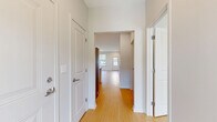 Located in Penfield, NY, this well-designed single-floor residence offers 2 bedrooms and 2 bathrooms within a thoughtfully arranged layout. Light-toned hardwood flooring flows consistently throughout the home, creating a cohesive and bright atmosphere. The open-concept kitchen and living area serves as the heart of the home, anchored by a large center island with a white quartz countertop and integrated sink. The kitchen features sleek white upper cabinetry, warm wood lower cabinets, a herringbone tile backsplash, stainless steel appliances including a French door refrigerator and built-in microwave, and track lighting overhead. The living area benefits from multiple windows dressed with horizontal blinds, filling the space with natural light and offering outdoor views. A glazed entry door adds additional brightness to the main living zone. The primary bedroom is a well-proportioned retreat with large windows and a dedicated walk-in closet equipped with wire shelving. Its en-suite bathroom features marble-style tile flooring, a wood-toned vanity with white countertop, a large mirror, and a glass-enclosed shower. The second bedroom is bright and comfortable, with multiple windows. The second bathroom offers a full tub-shower combo with clean white finishes and marble-style tile flooring.