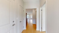 Located in Penfield, NY, this well-designed single-floor residence offers 2 bedrooms and 2 bathrooms within a thoughtfully arranged layout. Light-toned hardwood flooring flows consistently throughout the home, creating a cohesive and bright atmosphere. The open-concept kitchen and living area serves as the heart of the home, anchored by a large center island with a white quartz countertop and integrated sink. The kitchen features sleek white upper cabinetry, warm wood lower cabinets, a herringbone tile backsplash, stainless steel appliances including a French door refrigerator and built-in microwave, and track lighting overhead. The living area benefits from multiple windows dressed with horizontal blinds, filling the space with natural light and offering outdoor views. A glazed entry door adds additional brightness to the main living zone. The primary bedroom is a well-proportioned retreat with large windows and a dedicated walk-in closet equipped with wire shelving. Its en-suite bathroom features marble-style tile flooring, a wood-toned vanity with white countertop, a large mirror, and a glass-enclosed shower. The second bedroom is bright and comfortable, with multiple windows. The second bathroom offers a full tub-shower combo with clean white finishes and marble-style tile flooring.