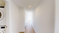 Located at 10141 124 St NW in Edmonton's vibrant Oliver neighbourhood, this modern 3-bedroom, 2-bathroom unit offers a well-designed single-level layout with a clean, contemporary aesthetic throughout. Light hardwood flooring flows seamlessly across all rooms, complementing the crisp white walls and creating a bright, cohesive feel.

The kitchen is outfitted with stainless steel appliances — including a refrigerator, electric range, built-in microwave, and dishwasher — paired with white upper cabinetry, wood-toned lower cabinets, and a grey tile backsplash. The open layout connects the kitchen to the living area, maximizing the sense of space.

Each bedroom benefits from large floor-to-ceiling windows that flood the rooms with natural light and offer impressive views of the Edmonton skyline and surrounding neighbourhood. The primary bedroom includes a walk-in closet with built-in shelving. A third bedroom provides a cozy, sunlit space ideal for a guest room or home office.

The two bathrooms are finished with white subway-style tile, wood-toned vanities, and white countertops. One bathroom features a soaker tub with shower, while the other offers a glass-enclosed walk-in shower. A dedicated in-unit laundry area with a stacked washer and dryer adds everyday convenience. A central hallway connects all rooms efficiently.