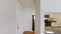 This 1-bedroom, 1-bathroom unit is thoughtfully laid out across a single floor, making efficient use of its space. The entryway welcomes you with wood-style flooring and crisp white walls, with a coat closet conveniently located near the front door for added storage. The kitchen is visible just off the entry and features stainless steel appliances, including a refrigerator and range, complemented by granite-style countertops and white cabinetry. The textured ceiling adds a subtle design element throughout the unit. The open flow of the layout connects the main living areas seamlessly, providing a functional and comfortable environment. The neutral color palette and clean finishes create a bright, move-in-ready atmosphere suitable for a variety of living styles. Whether utilized as a primary residence or a manageable urban retreat, this unit delivers a well-organized floor plan that maximizes every square foot of available space.
