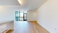 Located at 1280 Union St NE in Washington, DC, this thoughtfully designed two-bedroom, two-bathroom residence offers a clean, modern aesthetic across a single floor. The open-concept kitchen and living area serves as the heart of the home, featuring floor-to-ceiling cabinetry in a crisp white finish, a gas range, integrated appliances, and a breakfast bar with seating. Light wood flooring extends throughout, creating a warm and cohesive feel. The living room benefits from tall, black-framed windows that flood the space with natural light and frame views of the surrounding urban streetscape. A well-appointed hallway with recessed lighting and a full-length arched mirror connects the living areas to the private quarters. The primary bedroom includes a sliding-door closet and a window with city views, while the second bedroom offers similar bright, airy proportions and closet access. Both bathrooms feature modern tile work and clean-lined fixtures — one with a floating vanity, backlit medicine cabinet, and subway tile accents, and the other with a glass-enclosed walk-in shower and large-format floor tiles. The overall design emphasizes simplicity, functionality, and a contemporary urban sensibility throughout.