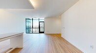 Located at 1280 Union St NE in Washington, DC, this thoughtfully designed two-bedroom, two-bathroom residence offers a clean, modern aesthetic across a single floor. The open-concept kitchen and living area serves as the heart of the home, featuring floor-to-ceiling cabinetry in a crisp white finish, a gas range, integrated appliances, and a breakfast bar with seating. Light wood flooring extends throughout, creating a warm and cohesive feel. The living room benefits from tall, black-framed windows that flood the space with natural light and frame views of the surrounding urban streetscape. A well-appointed hallway with recessed lighting and a full-length arched mirror connects the living areas to the private quarters. The primary bedroom includes a sliding-door closet and a window with city views, while the second bedroom offers similar bright, airy proportions and closet access. Both bathrooms feature modern tile work and clean-lined fixtures — one with a floating vanity, backlit medicine cabinet, and subway tile accents, and the other with a glass-enclosed walk-in shower and large-format floor tiles. The overall design emphasizes simplicity, functionality, and a contemporary urban sensibility throughout.
