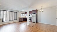Located in the heart of Los Angeles, this well-appointed one-bedroom, one-bathroom residence on N Hayworth Ave offers a thoughtfully designed single-floor layout. Warm hardwood-style flooring and crisp crown molding run throughout, lending a cohesive and polished look to every room.

The open-concept kitchen and living area form the heart of the home. The kitchen is equipped with rich, dark mahogany cabinetry, granite-style countertops, stainless steel appliances including a gas range, dishwasher, and full-size refrigerator, and a window that brings in natural light. A structural column subtly delineates the kitchen from the living area, which features recessed lighting, an elegant chandelier in the adjoining hallway, and large vertical-blind windows that allow ample light while offering privacy.

The bedroom is a comfortable, well-proportioned retreat with recessed lighting, crown molding, and a window with views of greenery outside. The bathroom retains a distinctive retro character, with classic mint-green tile work surrounding a full soaking tub, a frosted privacy window, and chrome fixtures that complement the vintage aesthetic. A hallway connects the rooms efficiently, completing this functional and charming Los Angeles residence.
