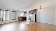 Located in the heart of Los Angeles, this well-appointed one-bedroom, one-bathroom residence on N Hayworth Ave offers a thoughtfully designed single-floor layout. Warm hardwood-style flooring and crisp crown molding run throughout, lending a cohesive and polished look to every room.

The open-concept kitchen and living area form the heart of the home. The kitchen is equipped with rich, dark mahogany cabinetry, granite-style countertops, stainless steel appliances including a gas range, dishwasher, and full-size refrigerator, and a window that brings in natural light. A structural column subtly delineates the kitchen from the living area, which features recessed lighting, an elegant chandelier in the adjoining hallway, and large vertical-blind windows that allow ample light while offering privacy.

The bedroom is a comfortable, well-proportioned retreat with recessed lighting, crown molding, and a window with views of greenery outside. The bathroom retains a distinctive retro character, with classic mint-green tile work surrounding a full soaking tub, a frosted privacy window, and chrome fixtures that complement the vintage aesthetic. A hallway connects the rooms efficiently, completing this functional and charming Los Angeles residence.