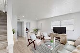 Located at 5420 NW 27th St in Lauderhill, Florida, this two-story home offers a thoughtfully designed layout spread across two floors. The main level opens into a bright, open-plan living and dining area with light wood-style flooring, recessed lighting, and large windows fitted with blinds that allow natural light to flow freely throughout. The living space comfortably accommodates seating and dining areas, with a dedicated office nook visible from the main room, featuring large sliding glass doors that overlook a lush green outdoor setting. The kitchen is a standout feature, boasting gray shaker-style cabinetry, granite countertops, a classic subway tile backsplash, and stainless steel appliances, all centered around a window above the sink. A laundry area and ample closet storage—six closets in total—add to the home's practicality. Upstairs, the primary bedroom is a serene retreat with generous proportions, large windows, and clean white walls. Both bathrooms are clean and functional, with one featuring a tub-shower combination and a window for natural light. The neutral, modern palette carried throughout the home creates a cohesive and inviting ambiance, making this property a comfortable and versatile residence.