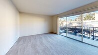 This well-organized one-bedroom, one-bathroom residence in Walnut Creek, CA (94596) offers a practical and comfortable single-floor layout. The living room serves as the heart of the unit, featuring plush carpeting, neutral-toned walls, and a large sliding glass door that opens to a private balcony, flooding the space with natural light and providing outdoor views of surrounding greenery and the neighborhood. The bedroom is a comfortably sized retreat, finished with soft carpeting, closet space, and a window with vertical blinds that allow natural light to filter in gently. The galley-style kitchen is efficiently designed with white cabinetry, dark granite-look countertops, a stainless steel sink, and wood-look flooring, complemented by ample upper and lower cabinet storage. A white refrigerator and range are included. The bathroom is clean and functional, featuring a white vanity with under-cabinet storage, a wall-mounted mirror, overhead lighting, a toilet, and a tub/shower combination, all set on warm wood-look flooring. Throughout the unit, a consistent palette of white and neutral tones creates a bright, cohesive atmosphere. This residence offers a straightforward, move-in-ready layout well-suited for individuals or couples seeking a manageable, low-maintenance living space.