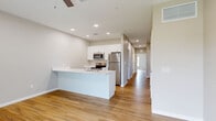 Located at 3108 Lockwood Ridge Rd. in Sarasota, FL, this 2-bedroom, 1-bathroom single-floor residence offers a clean, modern aesthetic with a cohesive design throughout. Light wood-look luxury vinyl flooring flows seamlessly across every room, complemented by neutral warm-gray walls and crisp white trim and baseboards.

The open-concept living and kitchen area serves as the heart of the home, featuring recessed lighting, a ceiling fan, and a peninsula-style kitchen with white cabinetry, stainless steel appliances — including a refrigerator, range, and microwave — and light countertops that provide ample prep space.

Both bedrooms are well-proportioned, with the primary bedroom offering a ceiling fan and a window with a roller shade that allows for natural light and outdoor views. Each bedroom benefits from sliding double-panel closet doors with raised detailing, providing generous storage. The secondary bedroom maintains the same clean, minimalist character with consistent flooring and wall tones.

The full bathroom is finished with matching flooring and neutral walls, and includes a full-size soaking tub/shower combination, a toilet, and a towel bar. A connecting hallway ties all rooms together efficiently. The overall design of the space emphasizes simplicity, functionality, and a bright, airy ambiance.