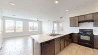 Located at 2620 Philomena St in Austin, TX, this 3-bedroom, 2-bathroom residence offers a thoughtfully designed single-level layout with a clean, modern aesthetic throughout. Light-toned tile flooring flows seamlessly across the entire home, creating a cohesive and easy-to-maintain living environment.

The heart of the home is an open-concept kitchen and living area. The kitchen features rich dark-brown cabinetry, light quartz countertops, a large peninsula island with an integrated sink and dishwasher, black appliances including a range and refrigerator, and recessed lighting overhead. The adjacent living area is bright and airy, benefiting from multiple windows and a ceiling fan that enhance comfort and natural light.

The three bedrooms are generously sized, with the primary bedroom offering built-in shelving and a private bathroom. Large windows in the bedrooms frame neighborhood views and allow ample sunlight to fill each room. Ceiling fans are present in the living and bedroom areas for added comfort.

The two bathrooms are finished with tile flooring and dark cabinetry with white countertops. The second bathroom includes a tiled tub-surround with a shower, a single vanity, and a window for natural light. The primary bath features open shelving for storage. The overall ambiance is clean, neutral, and move-in ready.