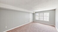 Located at 154 Fox Hill Ln in Enfield, CT, this single-floor, three-bedroom, two-bathroom home offers a practical and comfortable layout. The living area is bright and open, featuring wall-to-wall carpeting, neutral gray walls, a textured ceiling, and a large window dressed with vertical blinds that invites generous natural light. The updated kitchen is a standout feature, showcasing white shaker-style cabinetry, dark granite countertops, a single-basin stainless steel sink with a matte black faucet, and a full suite of stainless steel appliances. Light wood-look flooring ties the kitchen together with a clean, modern aesthetic. The generously sized primary bedroom offers ample floor space, plush carpeting, and large windows with views of the surrounding neighborhood. The two additional bedrooms are well-proportioned, each with carpeted floors, closets, and natural light. Three closets throughout the home provide excellent storage. Both bathrooms are finished with white cabinetry, granite vanity tops, and undermount sinks. One bathroom includes a walk-in shower with a white surround. Hallways connect the rooms efficiently, and a staircase is also present within the layout. The overall ambiance is clean, neutral, and move-in ready.