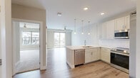 Located at 523 S Madison Ave in Greenwood, Indiana, this well-appointed one-bedroom, one-bathroom unit offers a thoughtfully designed single-floor layout with modern finishes throughout. The open-concept kitchen is a standout feature, showcasing crisp white shaker cabinets, a white subway tile backsplash, light quartz countertops, and a full suite of stainless steel appliances including a French door refrigerator, electric range, microwave, and dishwasher. A peninsula with pendant lighting above and an integrated sink adds both function and style, flowing seamlessly into the living area. The living room is bright and airy, benefiting from a ceiling fan and a sliding glass door that opens directly onto a private balcony with outdoor views. Warm-toned luxury vinyl plank flooring runs throughout the main living areas, while the bedroom features plush carpeting and a large window that fills the room with natural light. The bathroom is finished with marble-look tile surrounding the tub and shower combo, complemented by a white vanity and coordinating hardware. Additional conveniences include a dedicated laundry area, hallway, and closet, making this a complete and efficiently organized living space.
