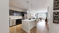 Located at 12 Merwin St in Norwalk, CT, this well-appointed two-bedroom, one-bathroom residence offers a thoughtfully designed layout across a single floor. The open-concept living and dining area is bright and welcoming, featuring light hardwood-style flooring, neutral toned walls, and large windows that frame views of the surrounding streetscape, flooding the space with natural light. The kitchen is a standout feature, boasting dark espresso cabinetry, a classic white subway tile backsplash, light quartz countertops, stainless steel appliances, and a central island with pendant lighting — ideal for both cooking and casual entertaining. The dining area benefits from a generous bay-style window arrangement, creating an airy, connected feel. Both bedrooms are carpeted and finished in soft, neutral tones, offering a calm retreat. The primary bedroom includes closet access and connects to the hallway, which also features a mirrored closet. The bathroom is clean and modern, with tile flooring, a dark vanity with white countertop, and a tiled tub-shower combo. A private balcony adds valuable outdoor space, rounding out this efficiently designed urban residence.