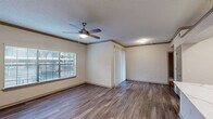 Located at 3700 Preston Rd in Plano, Texas, this one-bedroom, two-bathroom residence offers a well-organized single-floor layout designed for comfortable everyday living. The open living area features durable hardwood-style flooring, crown molding, a textured ceiling, and a ceiling fan with integrated lighting. Large windows fitted with blinds allow ample natural light to fill the space, creating a bright and welcoming atmosphere.

The kitchen is designed for both function and style, featuring white cabinetry, light stone countertops, a peninsula with a built-in sink, and a full suite of stainless steel appliances including a refrigerator, gas range, and microwave. Hardwood-style flooring continues throughout, lending a cohesive look to the common areas.

The bedroom is carpeted for comfort and includes a ceiling fan, a window with outdoor views, a spacious walk-in closet with built-in shelving, and direct access to a private en-suite bathroom. The bathrooms are finished with white cabinetry, light countertops, hardwood-style flooring, and a tiled shower-tub combination with brushed nickel fixtures and accents. A dedicated closet provides additional storage. The overall aesthetic is clean, neutral, and move-in ready.