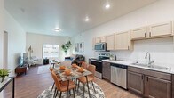This thoughtfully designed 1-bedroom, 1-bathroom unit offers an efficient and comfortable single-floor layout. The open-concept living, dining, and kitchen area creates a seamless flow, anchored by warm wood-look flooring throughout. The kitchen is well-equipped with stainless steel appliances including a refrigerator, range, microwave, and dishwasher, complemented by two-tone cabinetry featuring light upper cabinets and dark lower cabinets, and a clean marble-style countertop with a single-basin sink. A dedicated dining area sits adjacent to the kitchen, providing a functional space for everyday meals. The living room benefits from a large window that invites natural light and outdoor views, and offers ample space for comfortable seating arrangements. The generously sized bedroom features plush carpet flooring, a sizable window for natural light, and direct access to both the closet and full bathroom, providing a convenient and private layout. The bathroom includes a vanity with a marble-style countertop and a shower/tub combination. Throughout the unit, crisp white walls, recessed lighting, and distinctive wood-paneled interior doors contribute to a modern yet warm aesthetic.