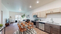 This thoughtfully designed 1-bedroom, 1-bathroom unit offers an efficient and comfortable single-floor layout. The open-concept living, dining, and kitchen area creates a seamless flow, anchored by warm wood-look flooring throughout. The kitchen is well-equipped with stainless steel appliances including a refrigerator, range, microwave, and dishwasher, complemented by two-tone cabinetry featuring light upper cabinets and dark lower cabinets, and a clean marble-style countertop with a single-basin sink. A dedicated dining area sits adjacent to the kitchen, providing a functional space for everyday meals. The living room benefits from a large window that invites natural light and outdoor views, and offers ample space for comfortable seating arrangements. The generously sized bedroom features plush carpet flooring, a sizable window for natural light, and direct access to both the closet and full bathroom, providing a convenient and private layout. The bathroom includes a vanity with a marble-style countertop and a shower/tub combination. Throughout the unit, crisp white walls, recessed lighting, and distinctive wood-paneled interior doors contribute to a modern yet warm aesthetic.