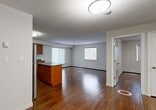 Located at 5403 162 Avenue NW, this 2-bedroom, 2-bathroom single-floor unit offers a functional and cohesive layout designed for comfortable everyday living. Rich hardwood-style flooring flows consistently throughout the space, lending warmth and visual continuity to every room.

The open-concept kitchen is a standout feature, equipped with stainless steel appliances including a refrigerator, electric range, built-in microwave, and dishwasher. Warm wood cabinetry provides generous storage, complemented by dark countertops and a classic subway tile backsplash. A central island adds additional prep and counter space, making the kitchen as practical as it is attractive.

The living area is bright and open, benefiting from multiple windows that invite natural light throughout the day. Both bedrooms are well-sized, with the primary bedroom offering a notably generous footprint. Each bedroom features windows with roller blinds and baseboard heating for year-round comfort.

The two bathrooms are consistently finished, each featuring warm wood vanities with dark countertops, a mirrored medicine cabinet, tile-surround tub-shower combinations, and neutral tile flooring. A dedicated closet completes the unit's storage offerings. The overall design is clean, practical, and move-in ready.