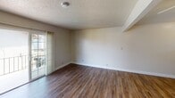 Located at 1231 Peach Pl in Concord, California, Unit L12 is a single-floor residence that offers a practical and well-organized layout. The living area is spacious and inviting, featuring durable wood-look vinyl flooring, a ceiling fan with integrated lighting, and a wall-mounted A/C unit for year-round comfort. A sliding glass door connects the living space to the outdoors, allowing natural light to fill the room. Adjacent to the living area, the kitchen is efficiently designed with dark espresso cabinetry, granite-toned countertops, a stainless steel sink, and white appliances including a refrigerator and stovetop. A window above the kitchen provides additional natural light and neighborhood views. The bedrooms are carpeted for comfort and feature textured ceilings, generous wall space, and ample natural light from well-placed windows. At least one bedroom includes a sliding-door closet with built-in shelving for storage. The bathroom connects directly to the main living areas and includes a vanity with storage. Throughout the unit, clean white walls and neutral tones create a bright, move-in-ready atmosphere suited for comfortable everyday living in the heart of Concord.